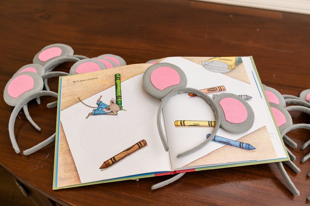 Gray felt mouse ear headbands resting on a page from If You Give a Mouse a Cookie