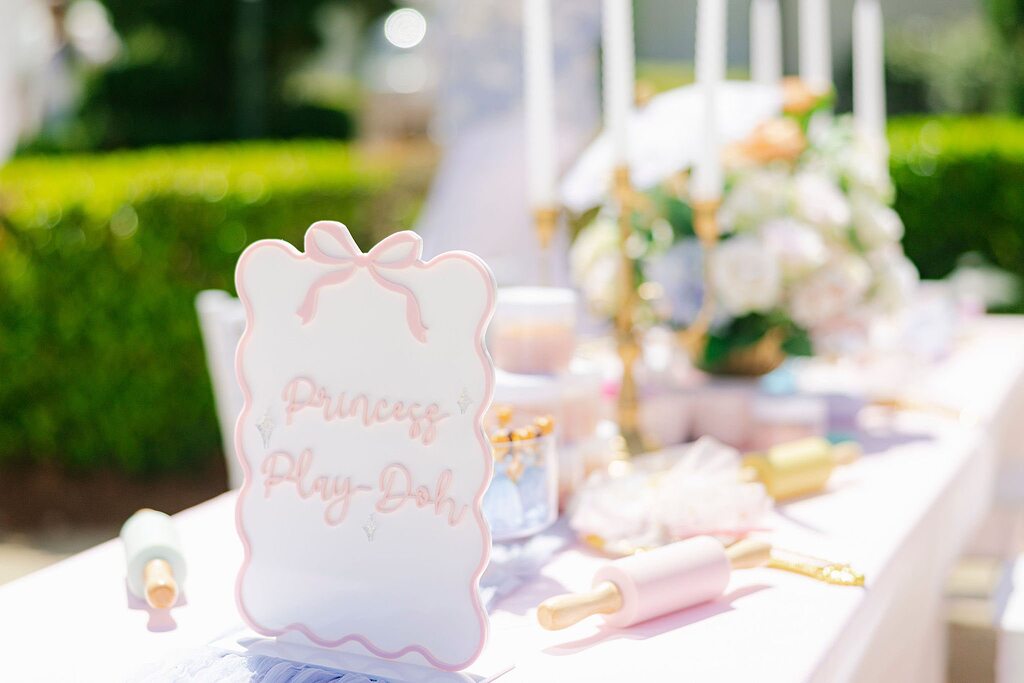 Table setting with a Princess Play-Doh sign, small rolling pins, and floral centerpiece.