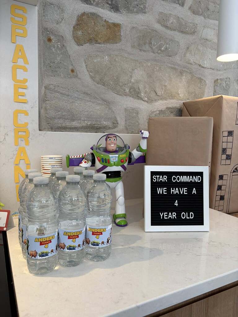 Toy Story inspired birthday display with water bottles labeled Anders Turns 4 and a sign saying Star Command we have a 4 year old.