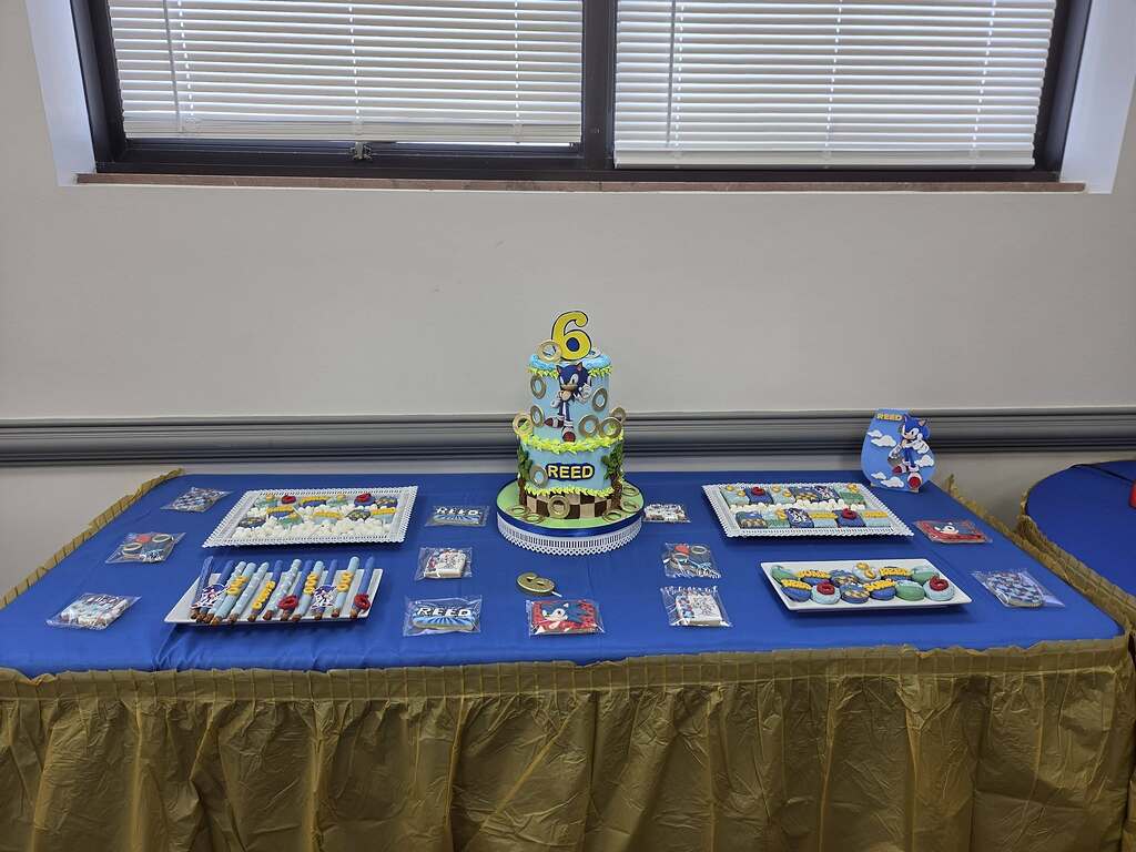 Sonic the Hedgehog themed birthday party table with a tiered cake, cookies, and treats for Reed's 6th birthday.