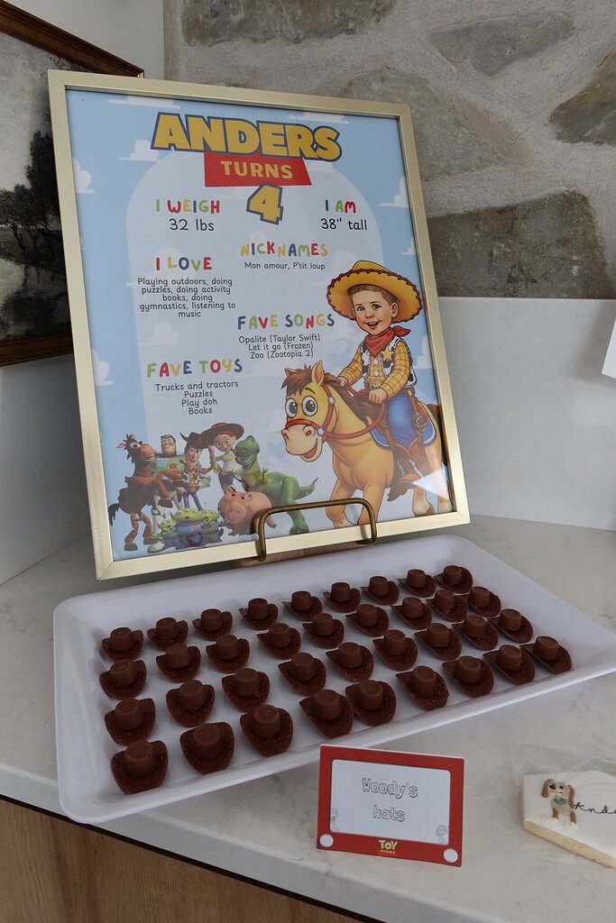 Toy Story themed birthday sign for Anders' fourth birthday next to a tray of cowboy hat-shaped chocolates.