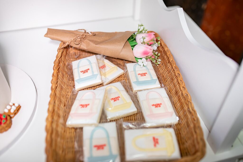 Woven basket filled with individually wrapped sugar cookies decorated to look like Trader Joe's canvas totes