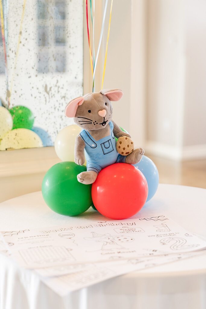 Plush If You Give a Mouse a Cookie character sitting on colorful party balloons