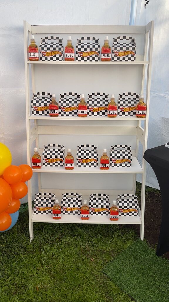 Shelves displaying Hot Wheels themed party favor boxes and Fuel energy drink bottles.