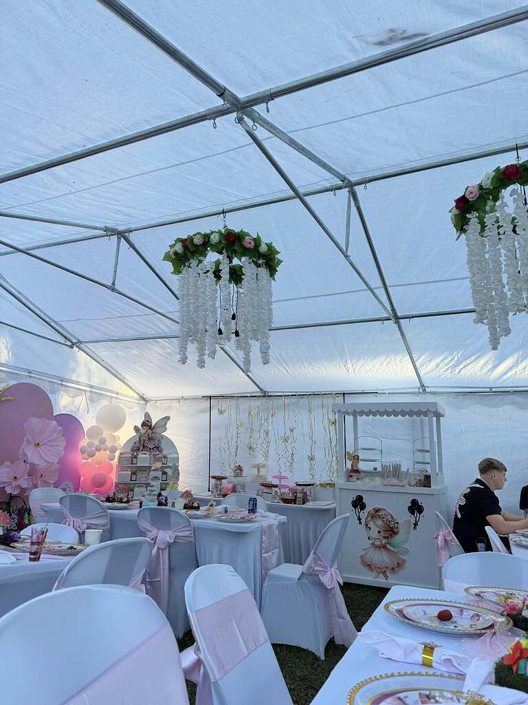 Event space set up with fairy-themed toddler birthday party decorations and floral chandeliers.