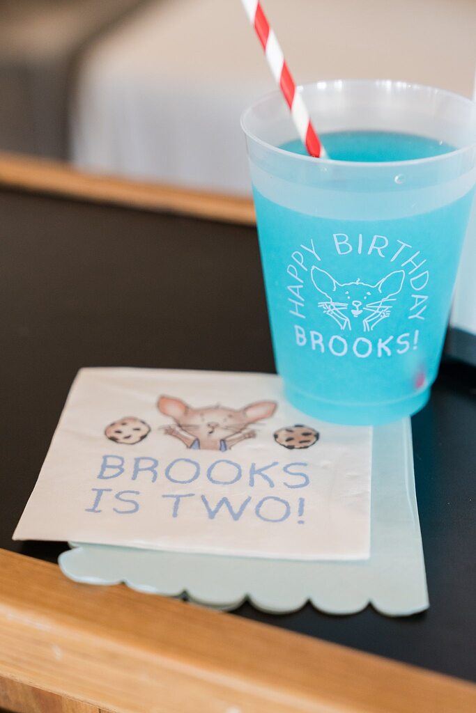Personalized blue party cup and napkin featuring a mouse illustration for a second birthday celebration.