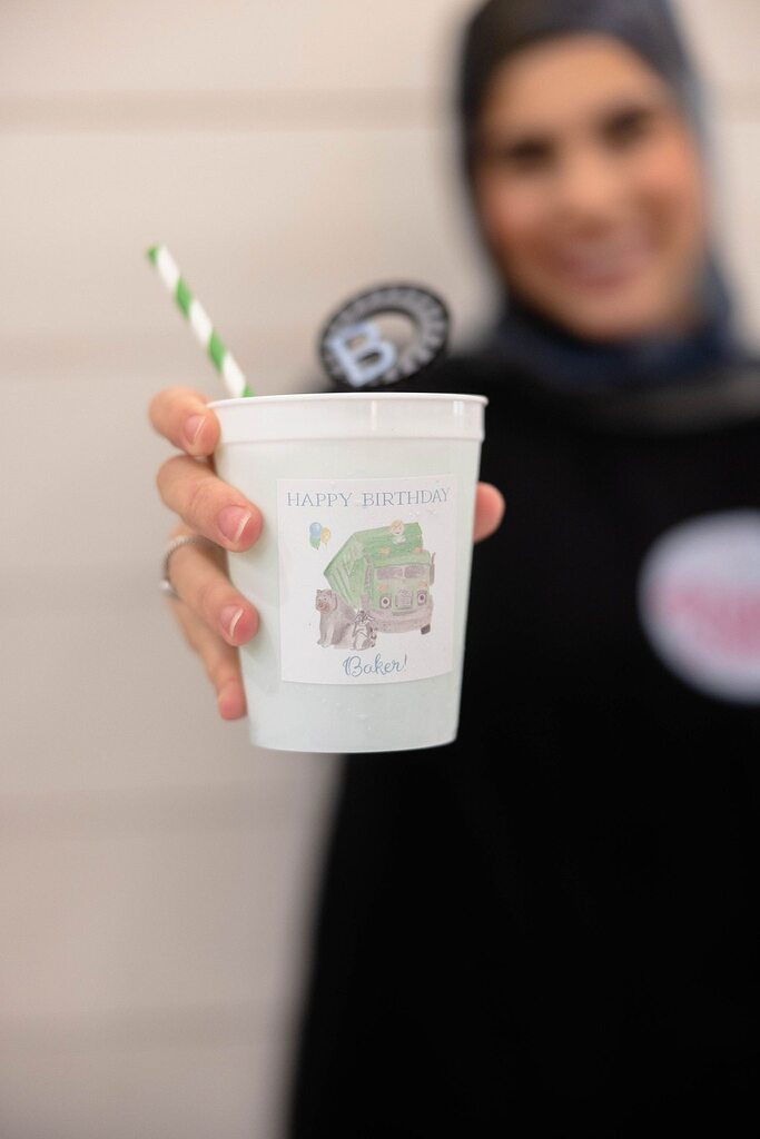 Personalized birthday party cup with a green garbage truck illustration and the name Baker