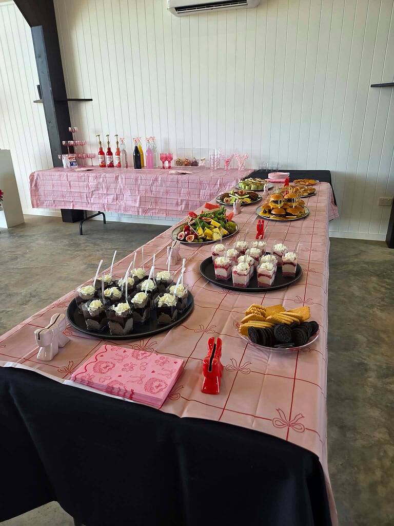 Table set with assorted dessert cups, appetizers, fresh fruit, and cookies at a party event