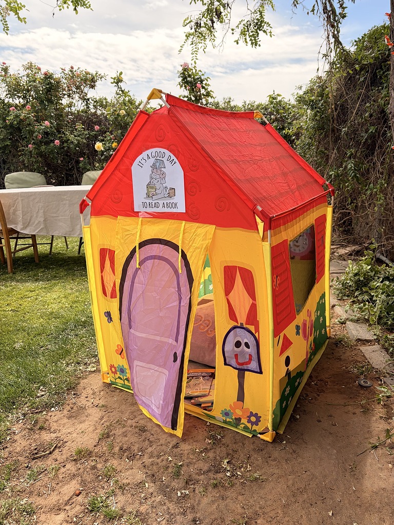Colorful toy play tent for kids with an It's a Good Day to Read a Book sign and mailbox character