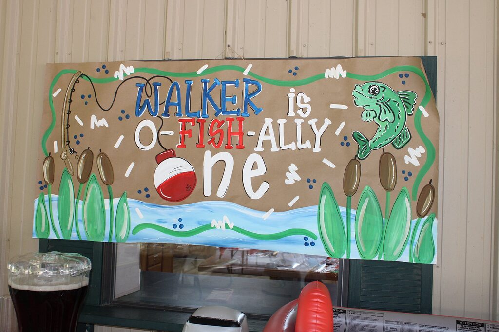 Handmade brown paper party banner with a fishing theme that reads Walker is O-Fish-Ally One.