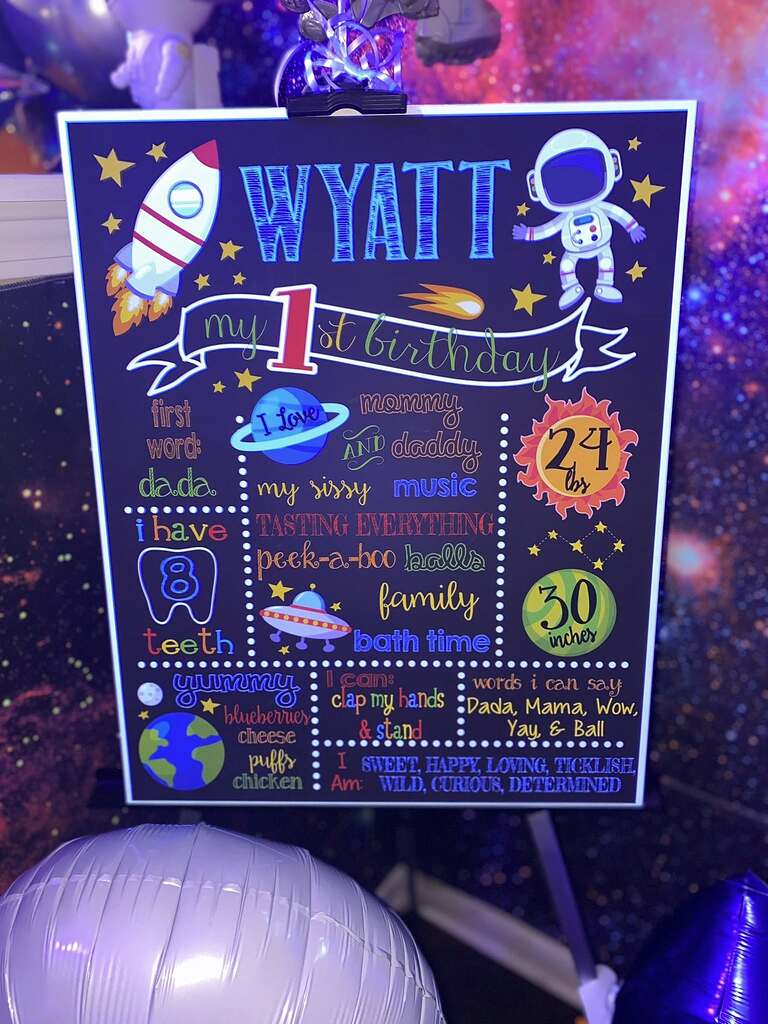 Space-themed chalkboard sign for Wyatt's first birthday detailing his current milestones and favorites.