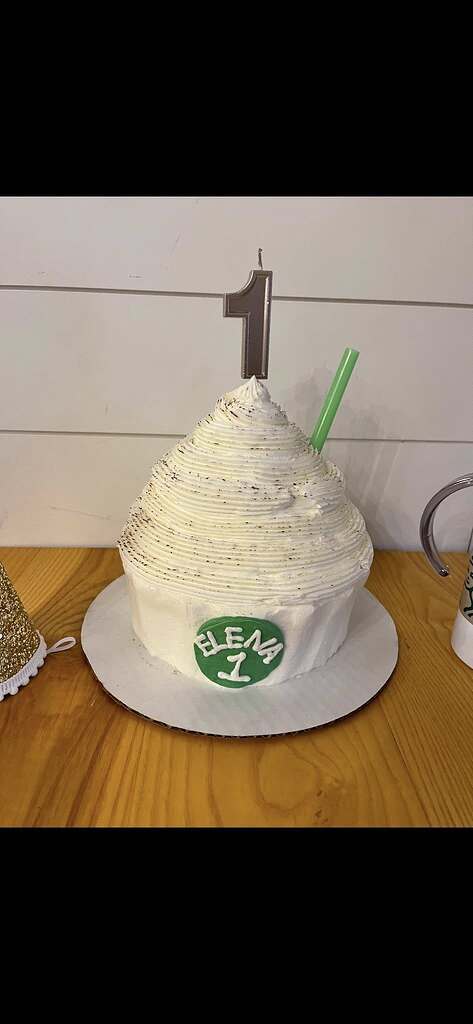 First birthday smash cake frosted with white icing and a number one candle on top