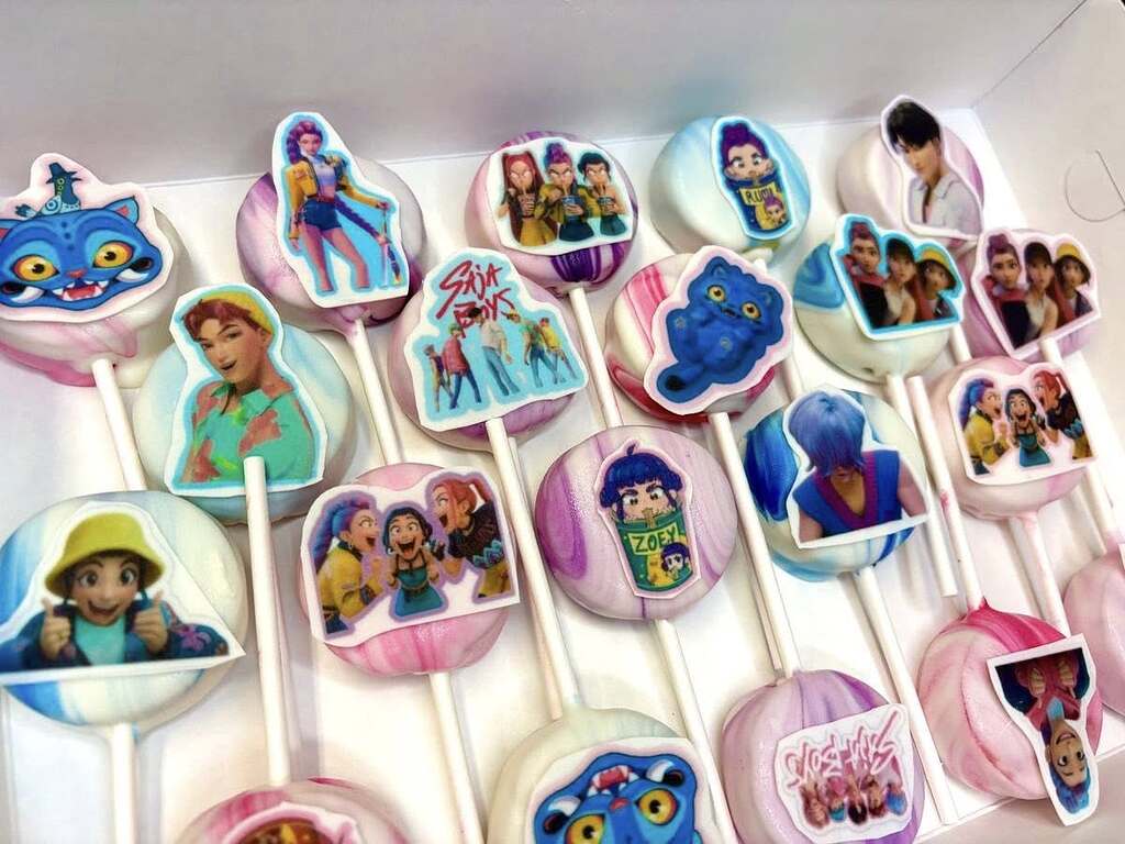 Box of cake pops decorated with edible pop culture character images and logos.