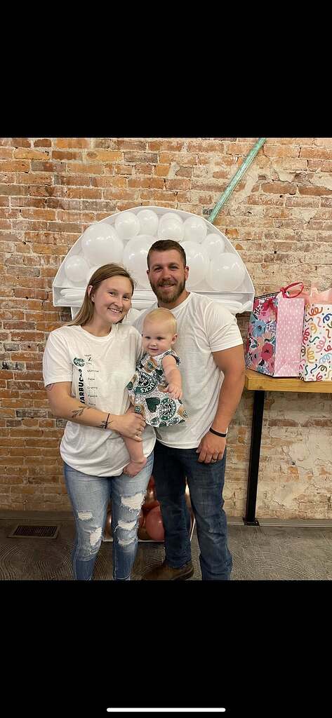 Family wearing matching Starbucks-themed apparel at a birthday party decorated with a coffee cup balloon display.
