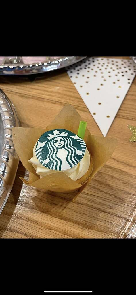 Cupcake topped with a Starbucks logo edible disc and a small green straw.