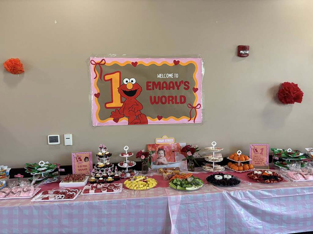 Elmo-themed first birthday party decorations and dessert table display.