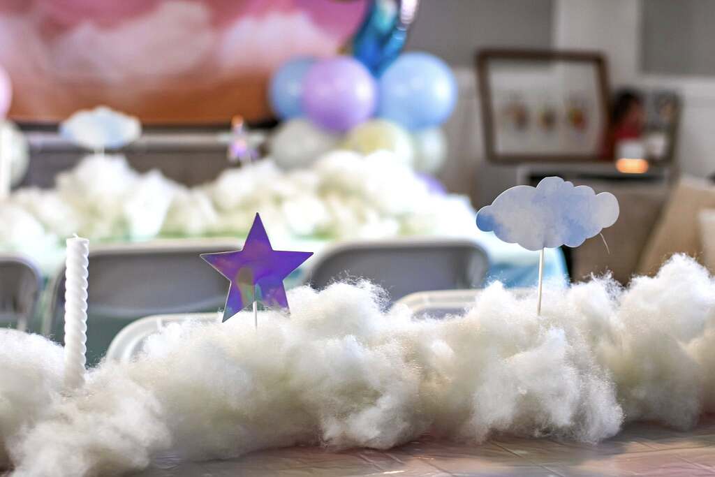Cloud and star themed birthday party table centerpiece with cotton clouds, star cutouts, and pastel balloons.