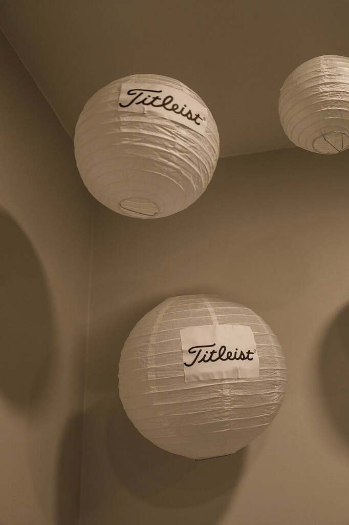 White round paper lanterns hanging with Titleist logo labels attached