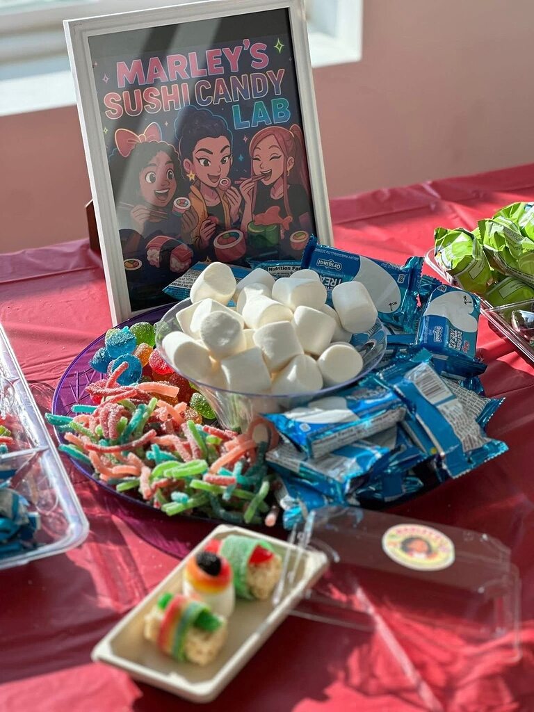 Table display for Marley's Sushi Candy Lab with marshmallows, gummy worms, Rice Krispies Treats, and candy sushi.